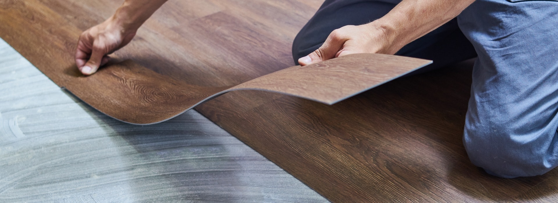 worker joining vinyl floor covering at home renovation